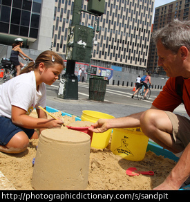 A child playing in a sandpit.