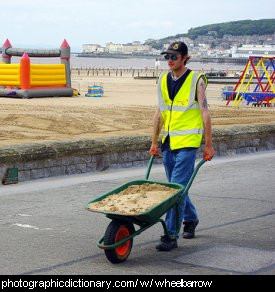 Photo of a man pushing a wheelbarrow