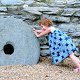 Photo of a girl pushing a stone.